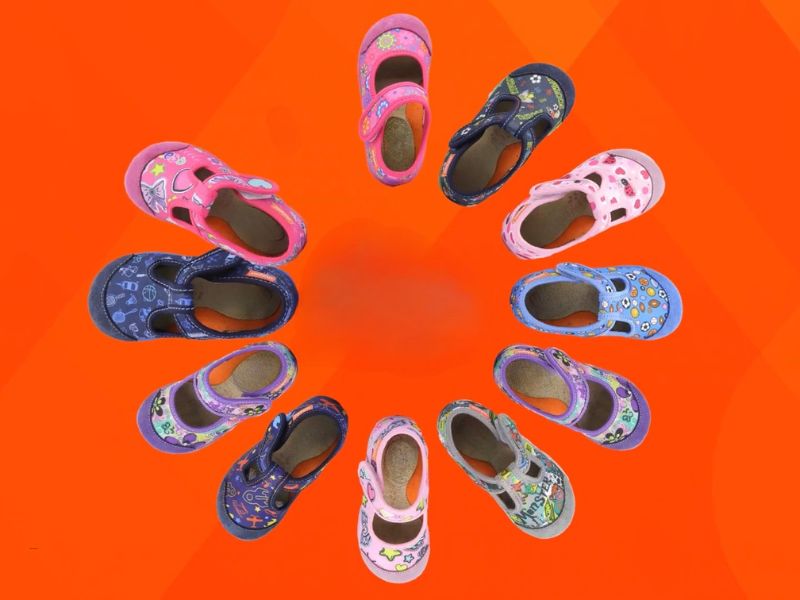 prikaz nekoliko pari dečijih patofnica na crveno narandžastoj pozadini