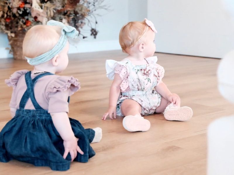 sređene bebe devojčice sede na podu